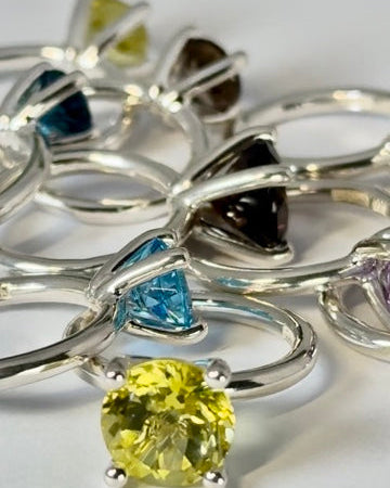 Många ringar Candy i silver med stenar i olika färger.