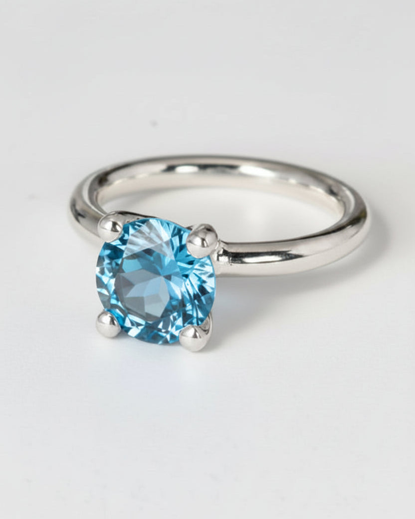 Ring i silver med blå facetterad rund sten, topas.